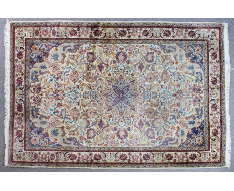 A Kashan carpet woven in pastel shades with a bold central medallion and conforming spandrels, the field filled with trailing