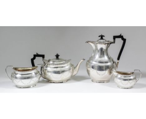 A George V silver oval four pierce tea service with bead mounts, the bodies engraved with ribbon and bellflower swag ornament