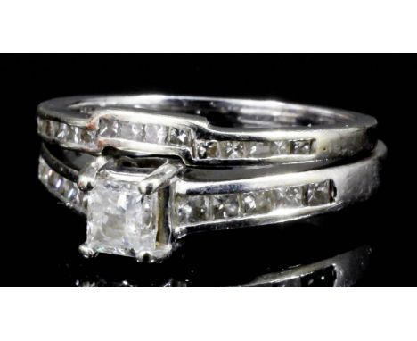 A modern 14k white gold mounted diamond solitaire, the princess cut stone of approximately .33ct, shouldered by four small br