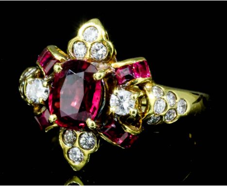 A modern 18ct gold mounted ruby and diamond ring, the central oval cut ruby of approximately .70ct, surrounded by four baguet