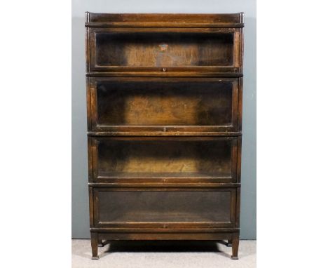 A Globe Wernicke oak four tier sectional bookcase, each tier with glazed rising front, on square tapered legs, 34ins wide x 1