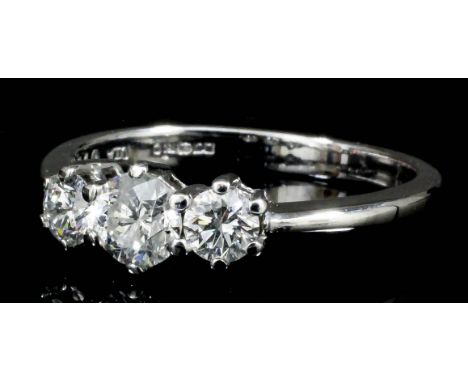 A modern 18ct white gold mounted three stone diamond ring, the central brilliant cut stone of approximately .33ct, flanked by