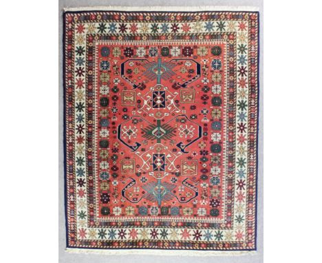 An Indian Kayam Amritzar carpet of "Caucasian" design woven in colours with bold hooked motifs and stylised flowerheads, on a