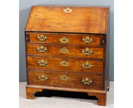 A George III mahogany bureau, the slope enclosing pigeon holes and eight small drawers, fitted four long drawers under, on br