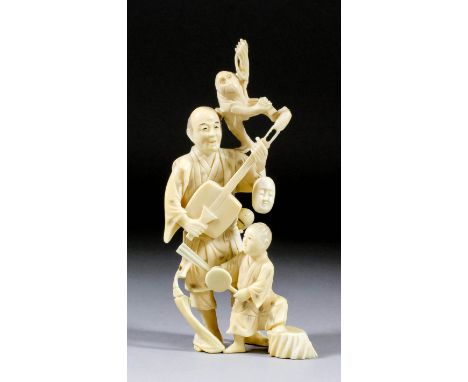 A Japanese carved ivory okimono of a standing entertainer playing a stringed instrument, a monkey on his shoulder, a child by