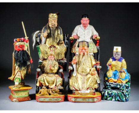 A Chinese carved polychrome and giltwood seated figure of Tudigong - The Earth God holding a sycee in his left hand, 10ins (2