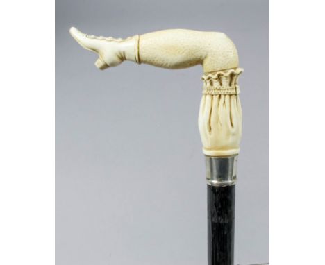 A late Victorian carved ivory and silver mounted "leg" pattern walking stick, the sectionally carved handle in the form of a 