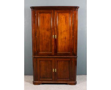 A 19th Century mahogany two-tier corner cupboard, the upper part with moulded cornice, the base fitted two shelves enclosed b