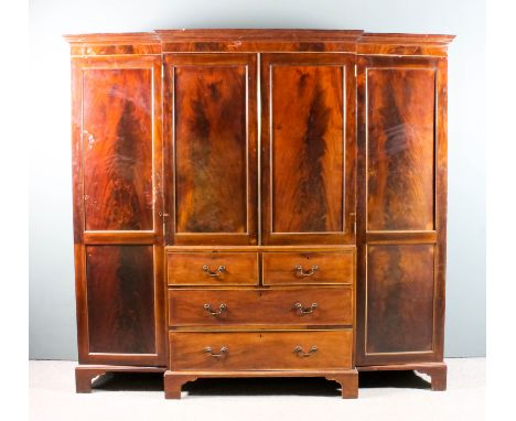 A mahogany break-front wardrobe of "Georgian" design, with moulded cornice, the centre now fitted with hanging compartment en