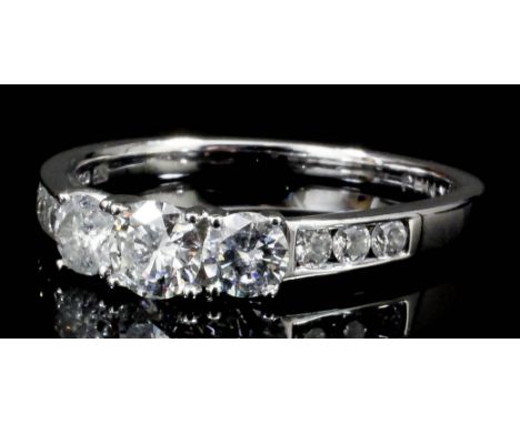 A modern 14ct white gold mounted three stone diamond ring, the face set with three brilliant cut diamonds, each approximately