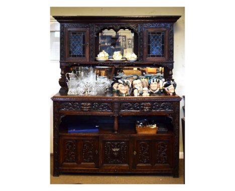 Late 19th/early 20th Century heavily carved mirror back sideboard, the upper section having two leaded glass doors, the base 