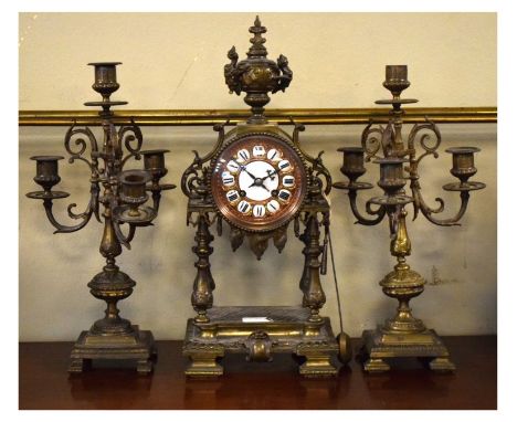 Early 20th Century French brass three-piece clock garniture, comprising: a portico clock with two-train movement and cellular