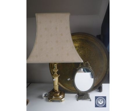 A circular folding Eastern brass table together with a brass table lamp with shade and a gilt metal dressing table mirror