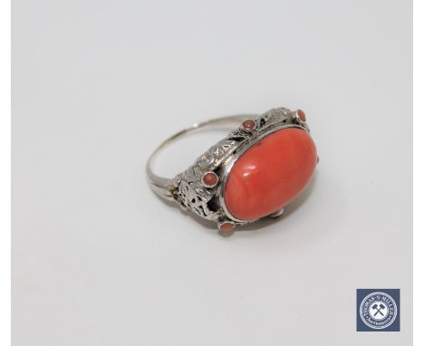 An antique coral ring set in white gold, size O