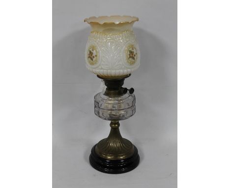 AN OIL LAMP WITH CLEAR GLASS RESERVOIR WITH LATER SHADE 