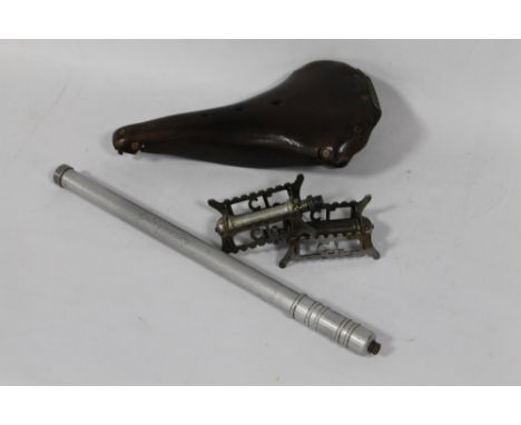 A VINTAGE LEATHER BROOKS B18 BICYCLE SADDLE, together with two vintage pedals and a bike pump. 