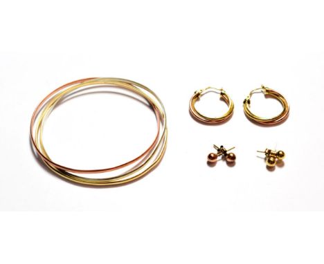 A 9 carat tri-colour gold triple band bangle; a pair of hoop earrings, stamped '375'; and two pairs of stud earrings, unmarke
