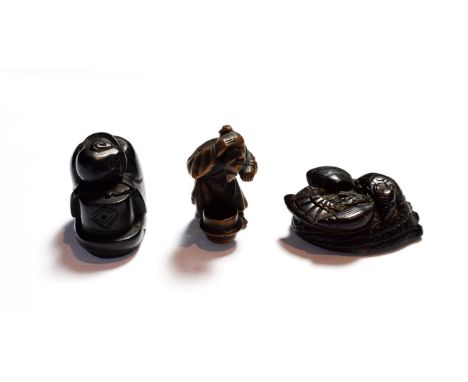 A Japanese wood netsuke, 19th century, as a crouching figure peering into a brazier, signed, 5cm high; a similar netsuke, as 