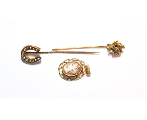 An 18 carat gold diamond set stick pin; a seed pearl horseshoe stick pin; and a cameo pendant, unmarked (3).  Diamond stick p