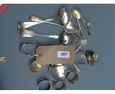 A collection of silver items including Georgian sugar tongs, a caddy spoon, Napkin rings and others, with silver plated items