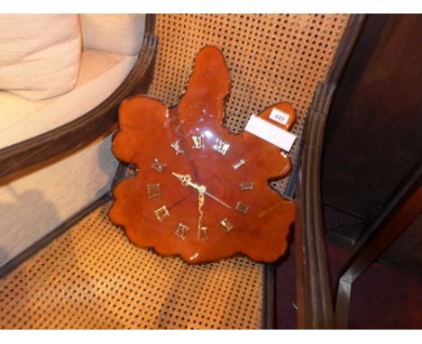 A wall clock formed from a slice of tree trunk with Roman numerals 