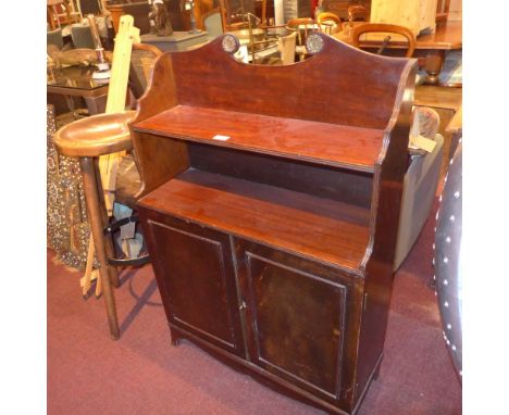 A late Victorian mahogany waterfall bookcase, the shelf over two cupboard doors, raised on splayed bracket supports, W 72 x D