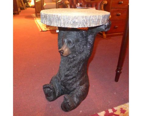 A black forest style occasional table in the form of a bear holding a slice of a tree trunk 