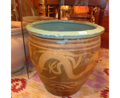 A large Chinese planter decorated with dragons chasing a pearl, on a brown ground, with blue interior 