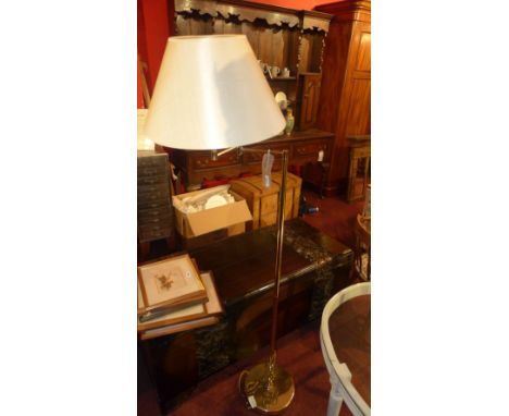 A brass adjustable standard lamp with shade 