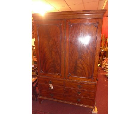 A Georgian mahogany linen press, with twin panel doors on bracket feet