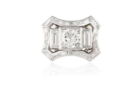 A DIAMOND DRESS RING, CIRCA 1950The transitional round-shaped diamond, within a four-claw setting, between baguette-cut diamo