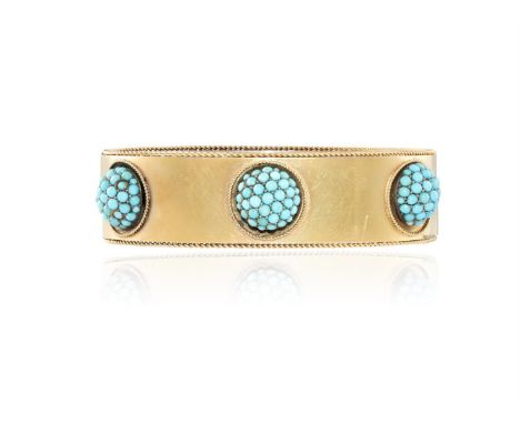 A LATE 19TH CENTURY TURQUOISE AND GOLD BANGLE, CIRCA 1870The bangle set with a trio of domed cluster cabochon turquoises, wit