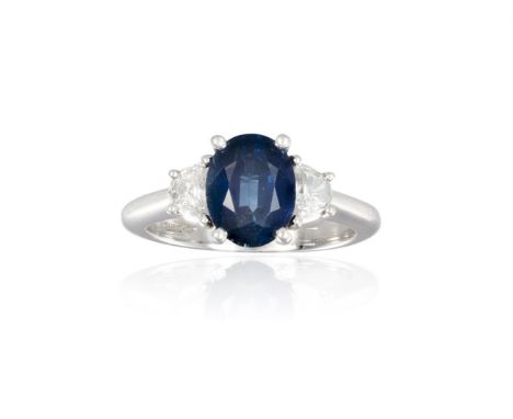 A SAPPHIRE AND DIAMOND RINGThe oval-shaped diamond, weighing approximately 2.50cts, within a four-claw setting, between two h