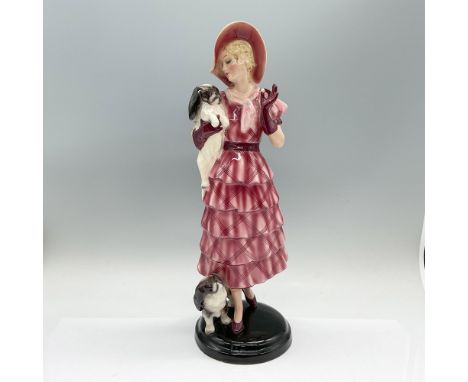 Art Deco figure of a young woman in a pink ruffled skirt with her two toy dogs. Goldscheider marked. Artist name on the under