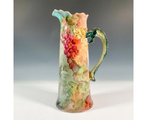 A beautiful tall pitcher with a gilded green dragon handle. The stunning jug is decorated with painted purple grapes and a gi