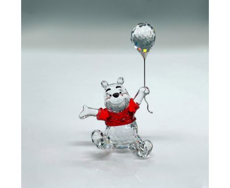 Clear faceted crystal figure of the classic bear sitting wearing a bright red shirt holding a balloon. Part of the Winnie the