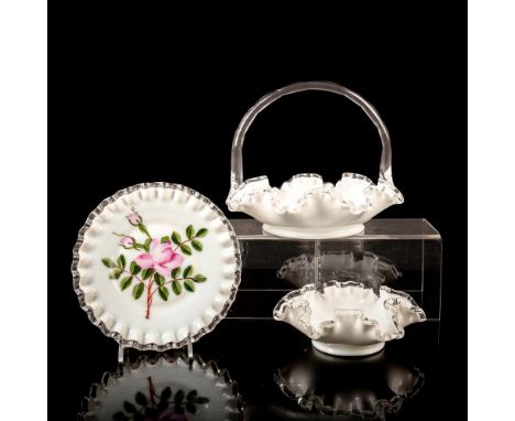 A set of 3 art glass pieces consisting of a white bowl, white basket with a clear handle, and a white plate with a blooming f