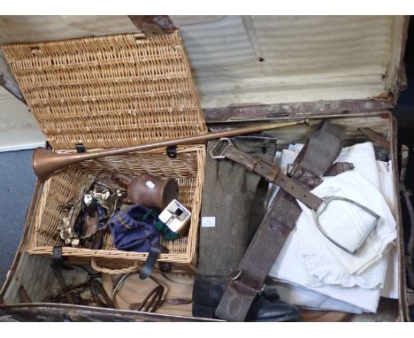 AN OLD TRAVELLING TRUNK containing a hunting horn, a carving board, linens and sundries