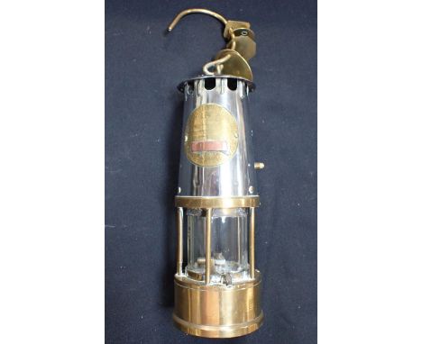 A MINER'S LAMP; 'THE PROTECTOR LAMP AND LIGHTING Co Ltd, ECCLES', with attached 'pit tokens' (plate over-polished)