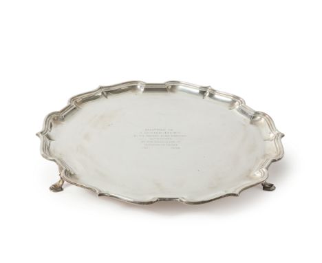 A large George VI silver salver. Mappin & Webb, Sheffield, 1936. Of shaped, circular form, raised on three pad feet and engra