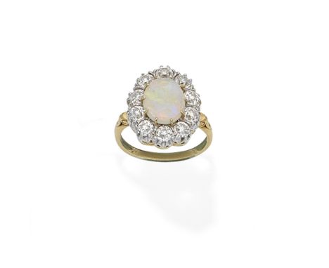 OPAL AND DIAMOND CLUSTER RING, 2000The opal cabochon within an old brilliant-cut diamond surround, mounted in 18 carat gold, 