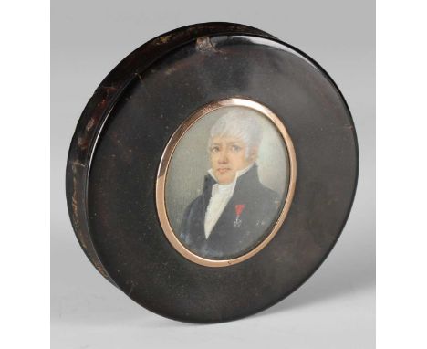 An early 19th century French tortoiseshell circular snuff box, the lid inset with a glazed portrait miniature of a gentleman 