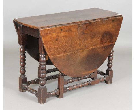 An 18th century oak oval gateleg supper table, on bobbin turned legs, height 72cm, length 144cm, depth 108cm.