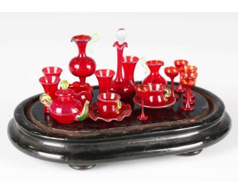 A group of late Victorian miniature cranberry glassware, including ewers, teapot, vases and plates, height of tallest 4.5cm, 