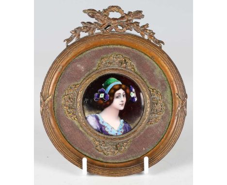 An early 20th century Limoges enamel tondo plaque, finely painted with a portrait of a young lady, initialled in gilt 'A.P', 