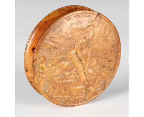 An early 19th century pressed maple circular snuff box, the lid decorated in relief with a titled scene of 'Champ de Waterloo
