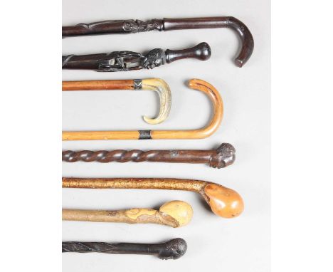 A group of various walking sticks, including a Victorian Malacca cane with rhino horn handle and silver collar, and a selecti