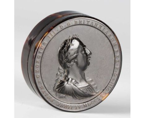A George III commemorative tortoiseshell circular snuff box, the lid pressed with a portrait of King George in profile, diame