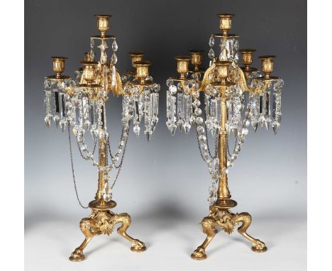 A pair of 19th century ormolu six-light candelabra, hung with chains and cut glass drops, raised on three zoomorphic monopodi