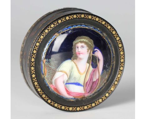 An early 19th century Continental tortoiseshell and gold piqué inlaid circular snuff box, the lid inset with an enamel on cop